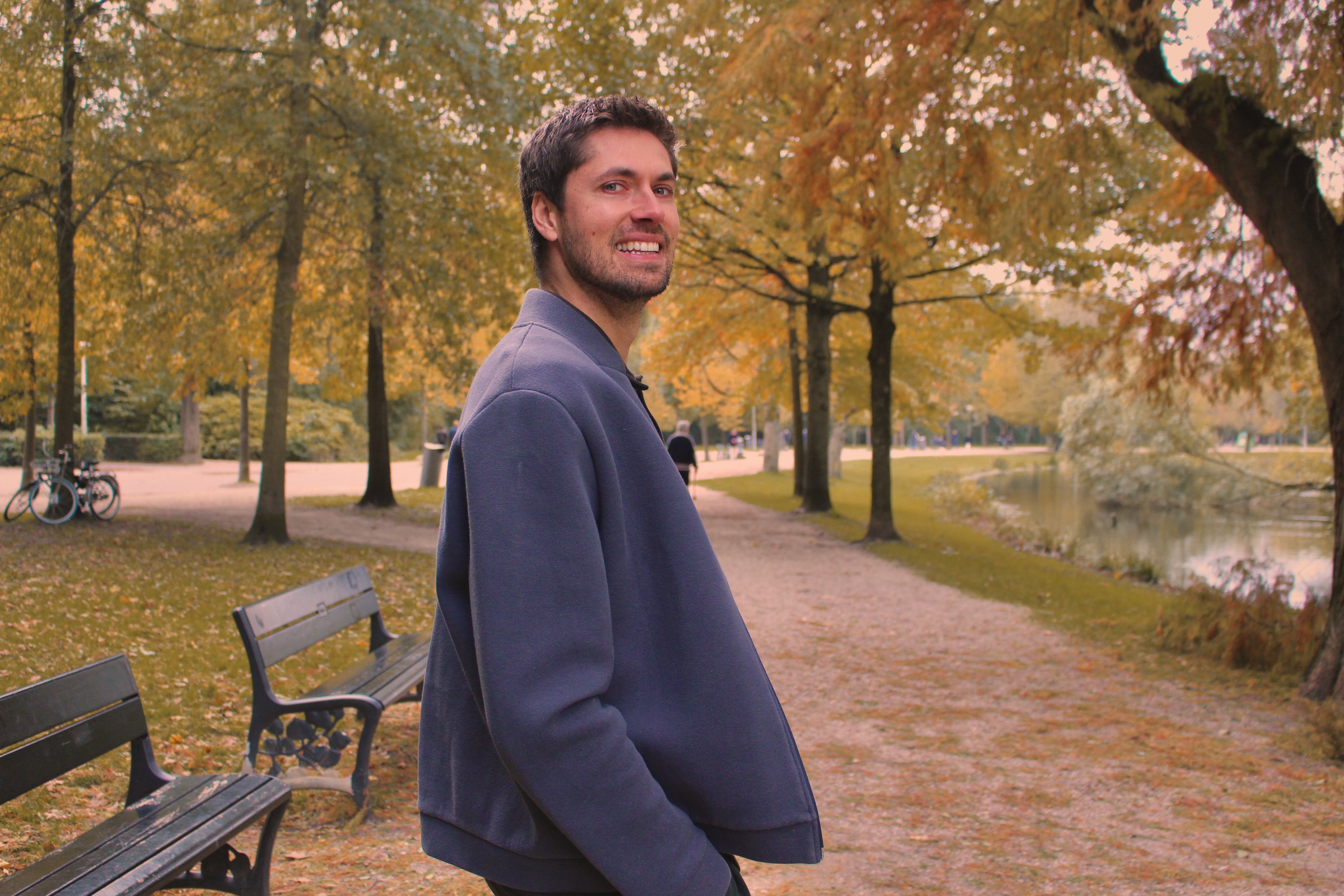 Alex smiling on a park path in Amsterdam